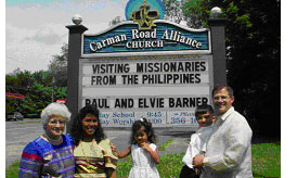 Paul, Elvie, Paul's Mom, Abigail and PJ standing in front af the Carman Road Alliance Church sign.