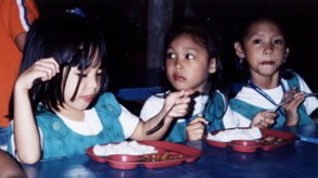 Three girls eating hot lunches