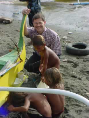 Paul with young Sea Gypsy children by a small boat.