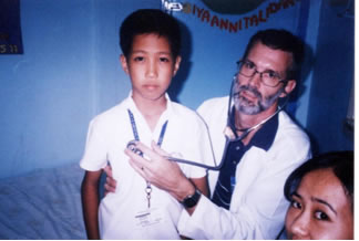 Dr. Evans holding stethscope to boy's chest