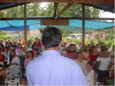 Pastor addressing large group.